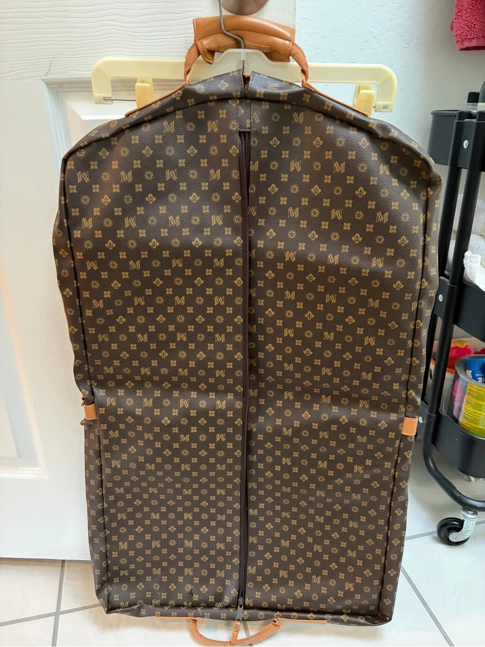 Vintage designer-style monogrammed garment bag with leather trim.